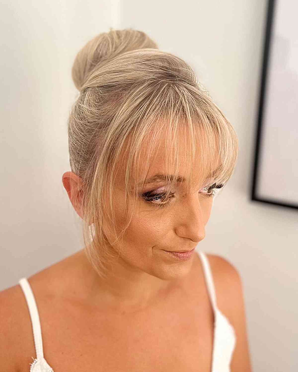 Formal Blonde Ballerina Bun Updo with Thin Bangs on Blonde Hair