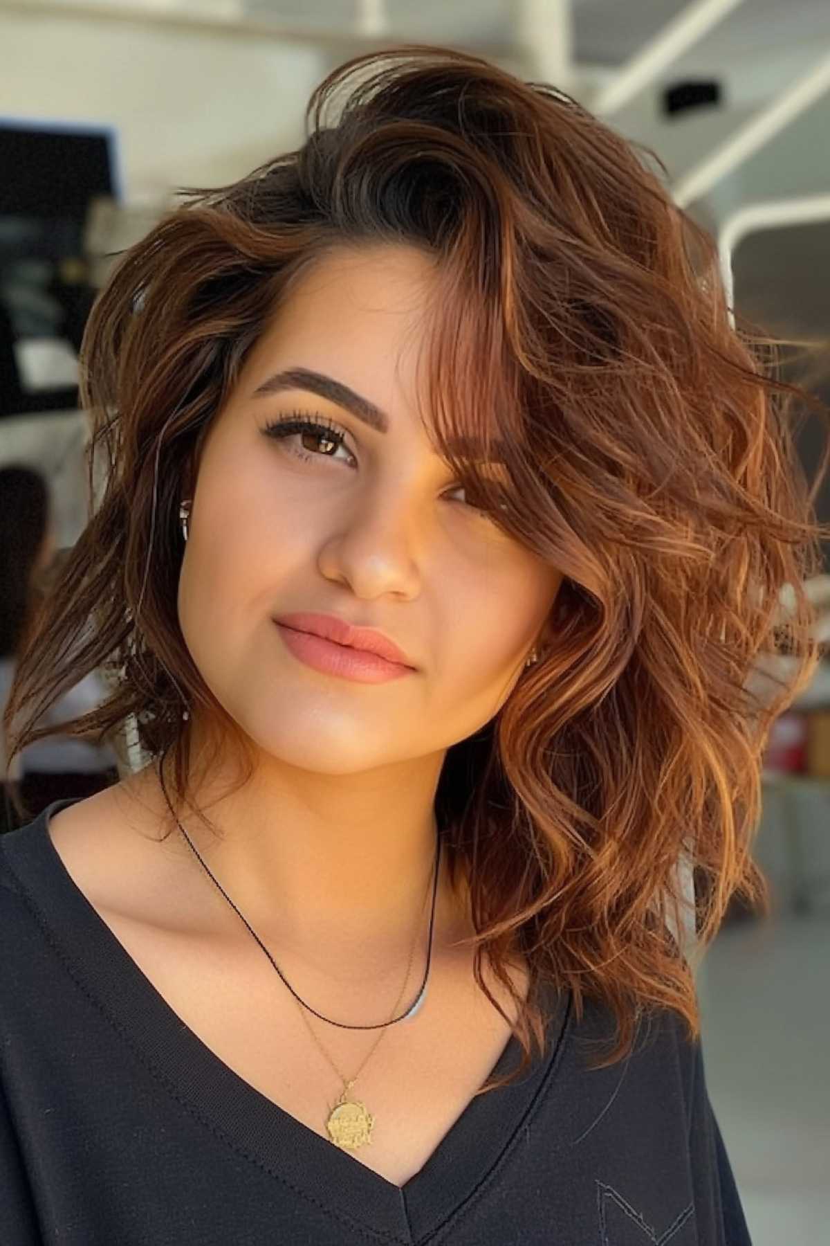 Long layered asymmetrical bob haircut with natural waves for medium to thick hair.